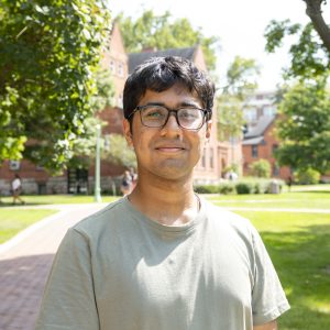 Lowell Monis in front of Eustace Cole Hall and neighboring buildings in the background.
